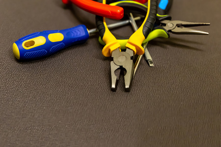 set of hand tools specialist in repairing electrical equipment close-up on a neutral gray backgroundの写真素材