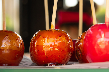 set festive colorful caramelized apples red yellow on a wooden stick festival circusの写真素材