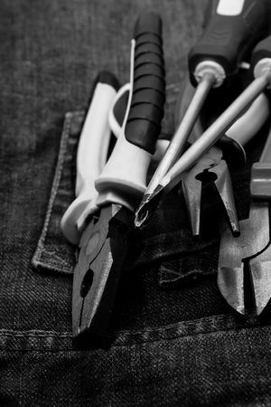 tools on the background of work clothes. vertical monochrome photo. Mites and pliersの写真素材