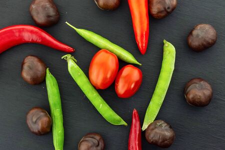 colorful vegetables harvest autumn tomatoes cherry pod green peas brown fruits chestnut chili peppersの写真素材