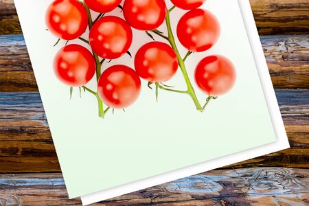 branch ripe red cherry tomatoes bright set of vegetables lies on a light background and wooden baseの写真素材
