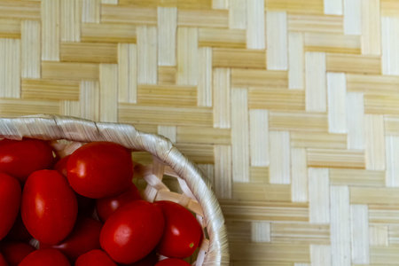 red ripe tomato many vegetables, used for cooking salsa sauce, lies in a basket and on a light beige...
