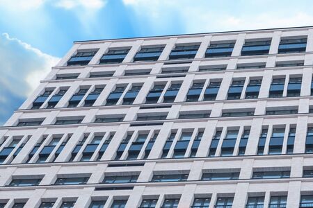 house facade tall building white gray large windows against the sky architectural design basisの写真素材