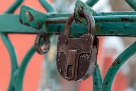 closeup rusty padlock old grille wicket green protection of the territory deadboltの写真素材