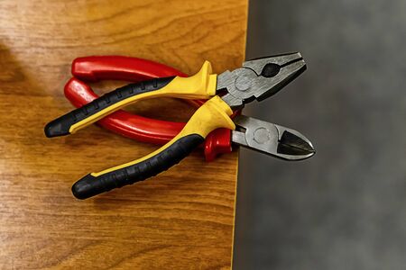 pair of pliers bright handles plastic yellow red working hand toolsの写真素材