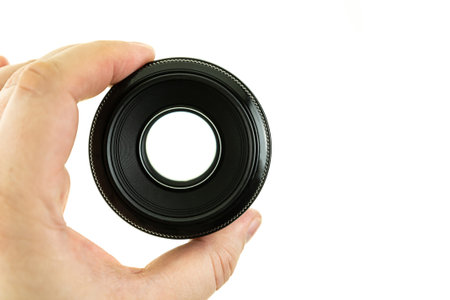 black photo lens in hand close-up on an isolated background, view through the lens