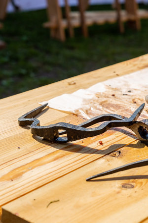 an iron a grill clamp for fixing meat on a picnic skew lies on a table vertical photo