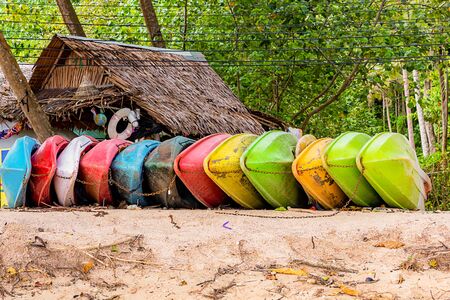 boat made of light plastic red, green, yellow and pink on a tropical island sandy beachの写真素材