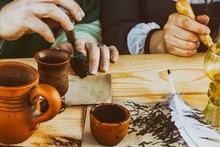 ink black print clay inkwell hand parchment stained background soft lightの写真素材