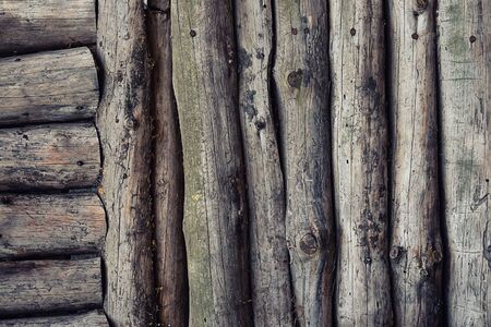 The wall consists of logs vertical horizontal trunks. Wooden ribbed pattern old weathered blocks tintedの写真素材