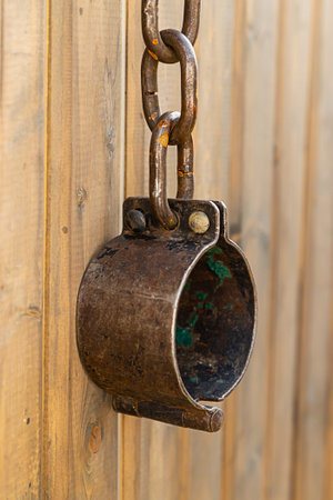 iron old shackles captivity slaves oppression of man whist on a wooden wall