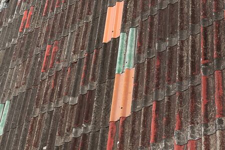 old rusty roof with bright plates red blue vertical patternの写真素材