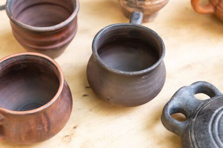 A pottery set consists of a pair of pots and a flask on a wooden backgroundの写真素材