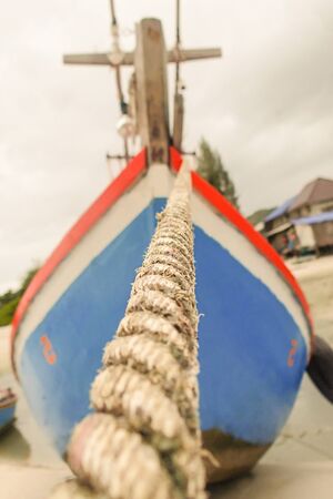old cable for mooring on the background of a blurred board of a bright shipの写真素材