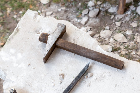 hammer and chisel of the quarry, processing and extraction of stone lies on the edge of the white...