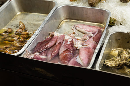 Asian market marine delicacy tray with fresh squid carcass and shells, a choice of products for...