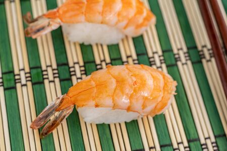 two sushi with fresh nigiri prawns on a light green backgroundの写真素材