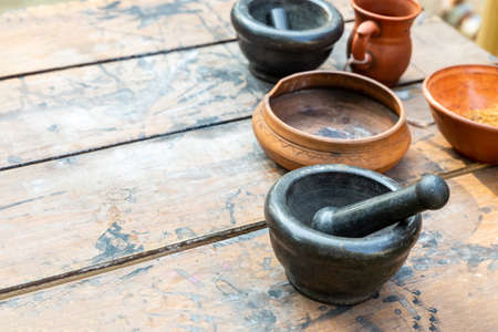 set of dishes mortar with pestle black and clay plate on the tableの写真素材