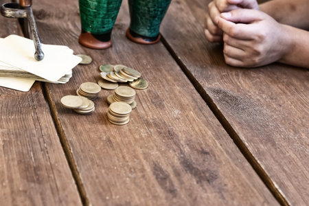 card game stack of cards and stack of coins on wooden table
