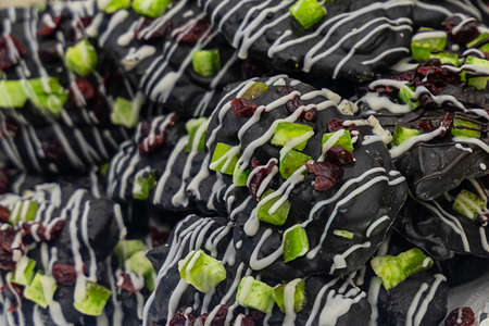 marzipan almond candies in dark glaze and candied fruitsの写真素材