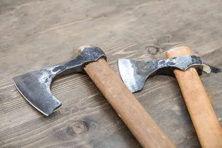 pair of viking battle axes close up on wooden backgroundの写真素材