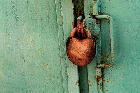 padlock rusty hanging on the background of an iron gate close-upの写真素材