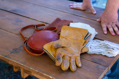 set of hunter accessories leather jar round and gloves folded on the tableの写真素材