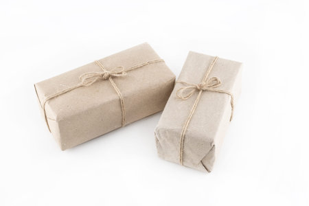pair of giftbox in light brown packaging wrapped with twine on isolated backgroundの写真素材