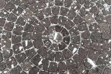 pavement folded in a circle, stone tiles area covered with snowの写真素材
