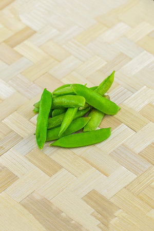 few pods of green peas, fresh vegetables harvest on the wooden background