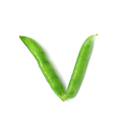 alphabet from vegetables, the letter from peas folded V on a light backgroundの写真素材