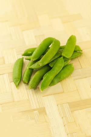 handful of fresh peas in pods on a wooden background