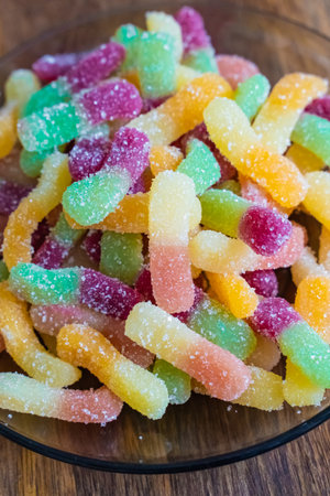 jelly candies on glass plate on wooden backgroundの写真素材