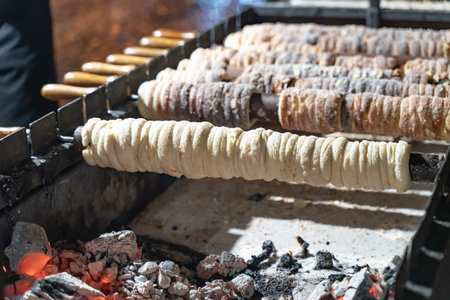 trdelnik prague specialty dessert cooked on a campfire close up selective focus, ready and uncookedの写真素材