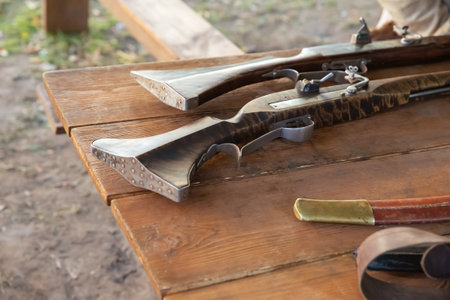 old shotgun with a wooden barrel and an iron stock close-upの写真素材