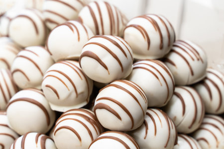 slide of chocolates covered with white chocolate and lines from brown close-upの写真素材