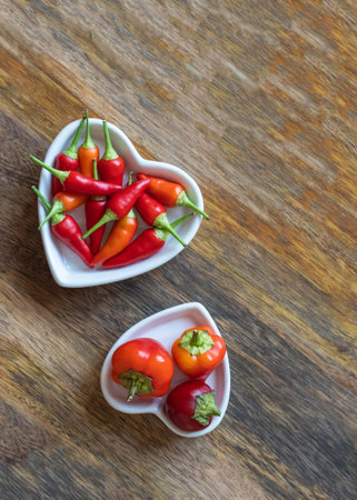 plate full of hot red peppers on wooden background
