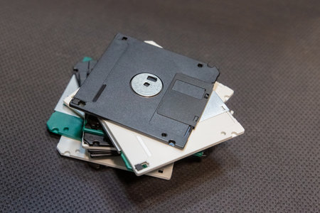 stack of old floppy disks stacked on a table, obsolete disk mediaの写真素材