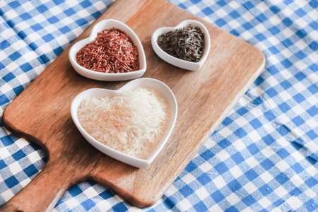 assorted rice red and black in a plate on a wooden backgroundの写真素材