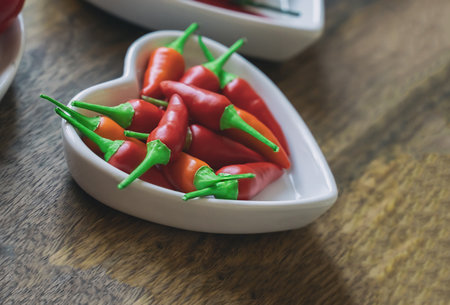 heart shaped plate with fresh chili pepper close upの写真素材