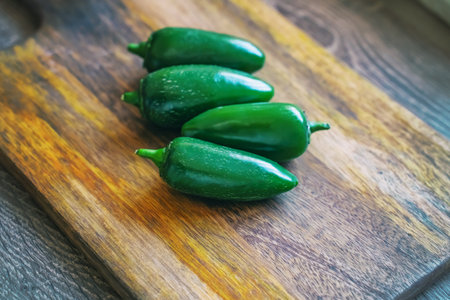 jalapeno fresh green hot chili peppers on wooden background, cutting boardの写真素材