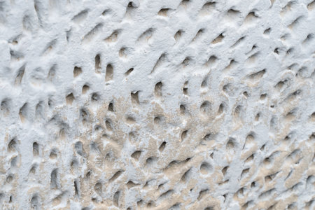 uneven stone wall light close-up with holesの写真素材