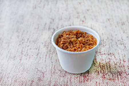 fried crunchy onion in white glass closeup with copy space