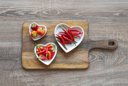 red chili pepper fresh on a white plate in the form of a heart on the boardの写真素材