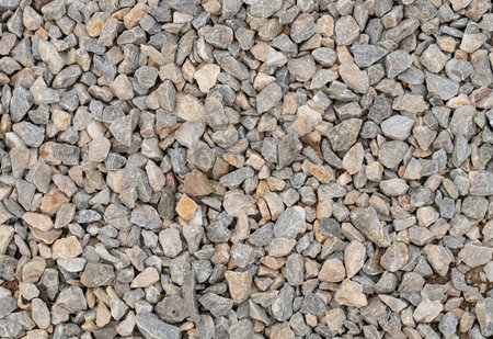 gray stone background of many small cobblestones, pebbles river bank