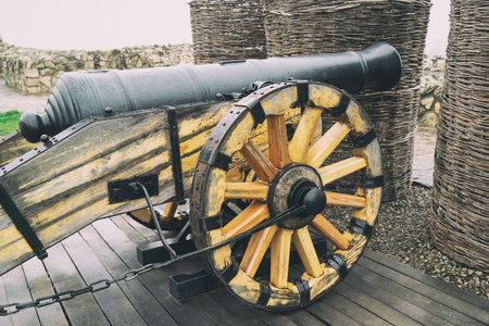 cannon with wooden wheels on the background of the fortress, a defensive weaponの写真素材