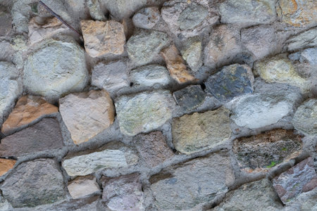 stone fence of uneven cobblestones gray and brown patternの写真素材
