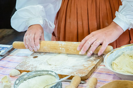 woman rolls out the dough for pies with a rolling pin close up