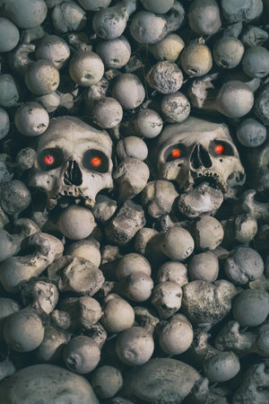 creepy pattern human skull with red eyes among bones close up pattern halloweenの写真素材