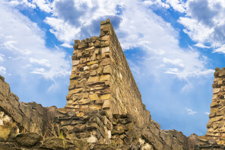 the ruined wall of the fortress, laid out of stones, stands on a hill, a fortificationの写真素材